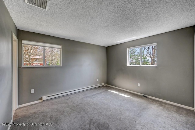 carpeted empty room with a textured ceiling, visible vents, baseboard heating, and baseboards