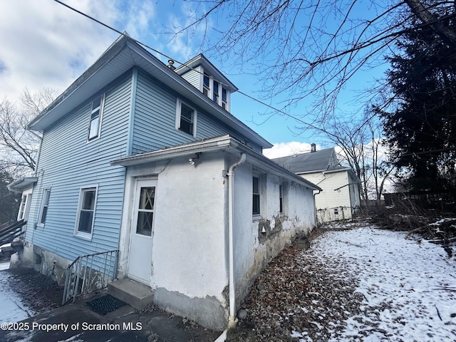 view of snow covered exterior with entry steps