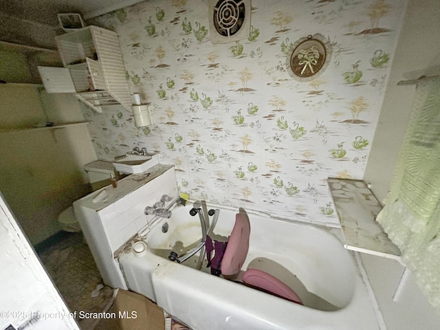 bathroom with a tub to relax in and wallpapered walls