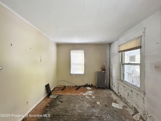 empty room featuring radiator heating unit and crown molding