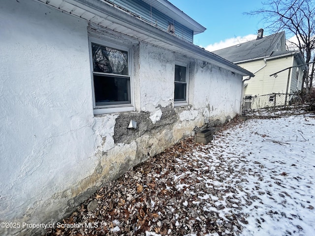 view of side of property featuring fence and stucco siding