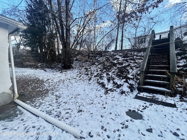 yard covered in snow featuring stairs