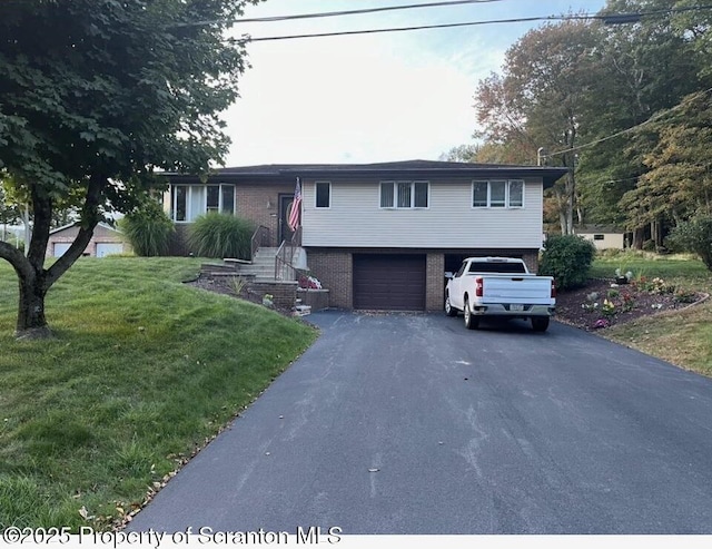 view of front of home featuring a garage, driveway, a front lawn, and brick siding