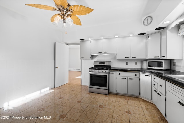 kitchen with white cabinetry, light tile patterned floors, a baseboard radiator, and white appliances