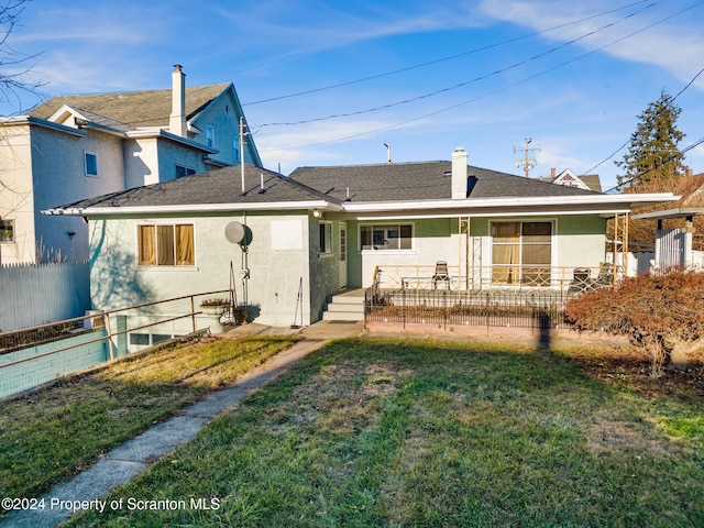 rear view of property featuring a lawn