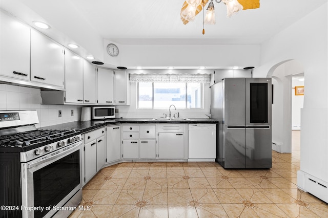 kitchen featuring white cabinets, light tile patterned floors, baseboard heating, and appliances with stainless steel finishes