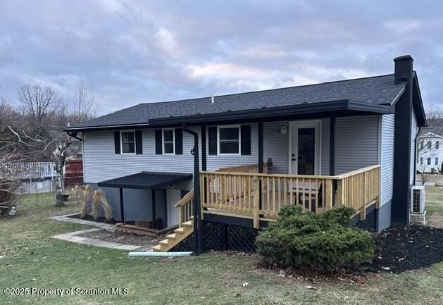 view of front of house featuring a deck and a front yard