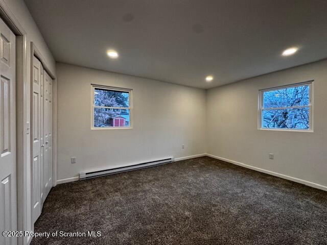 interior space featuring a baseboard radiator and dark colored carpet