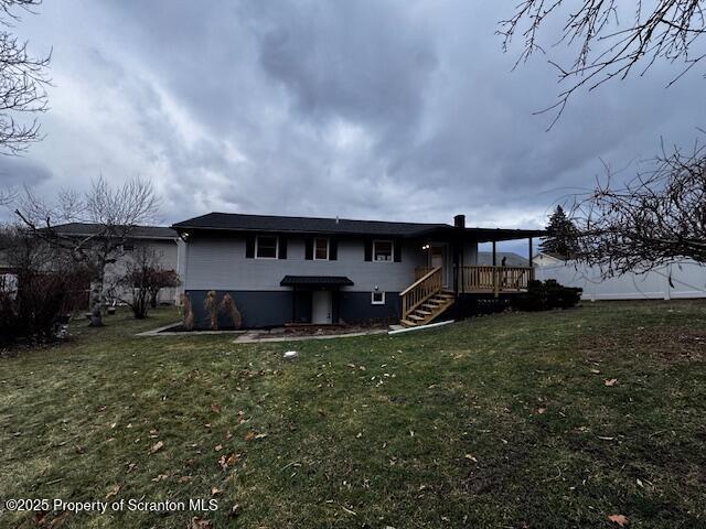 rear view of house with a lawn and a deck