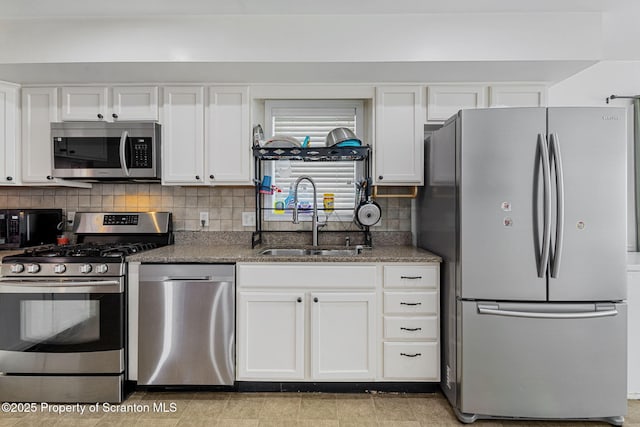 kitchen with stainless steel appliances, white cabinets, and sink