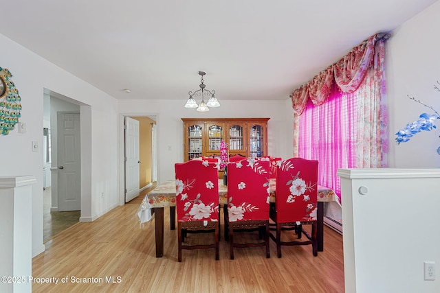 dining area featuring an inviting chandelier and light hardwood / wood-style floors