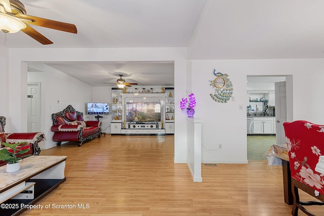 living room with ceiling fan and light hardwood / wood-style flooring