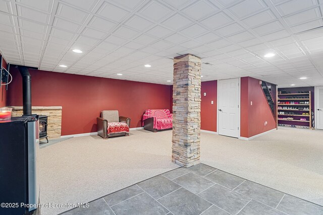 basement featuring carpet and a wood stove