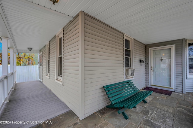 view of exterior entry featuring covered porch