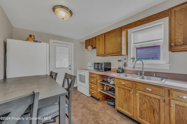 kitchen featuring stove, white refrigerator, and sink