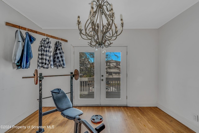 workout room with french doors, a chandelier, and hardwood / wood-style flooring