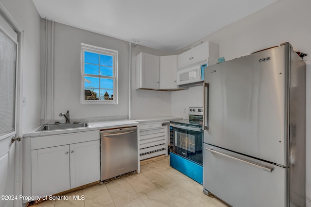 kitchen with stainless steel appliances, white cabinetry, and sink