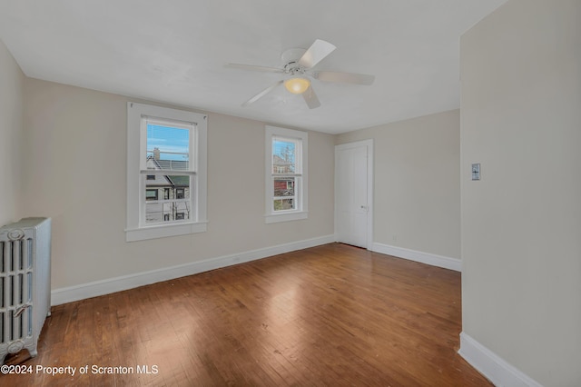 unfurnished room featuring radiator heating unit, ceiling fan, and wood-type flooring