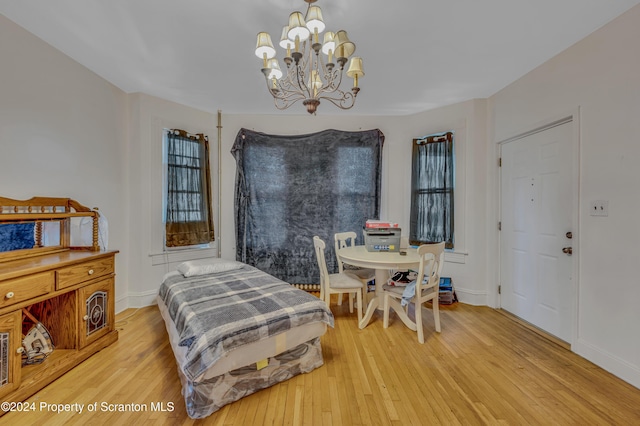 bedroom with an inviting chandelier and hardwood / wood-style flooring