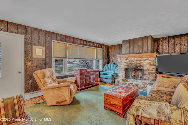 living area with wood walls, carpet, a baseboard heating unit, and a stone fireplace