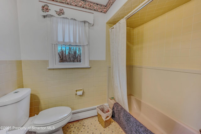 full bath featuring tile walls, shower / bath combination with curtain, toilet, a baseboard heating unit, and wainscoting