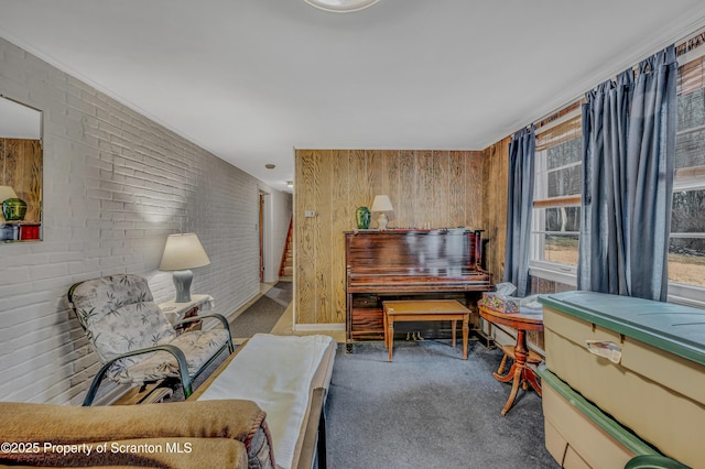 sitting room featuring carpet floors and brick wall