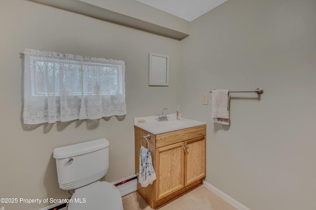 half bathroom featuring baseboards, vanity, and toilet