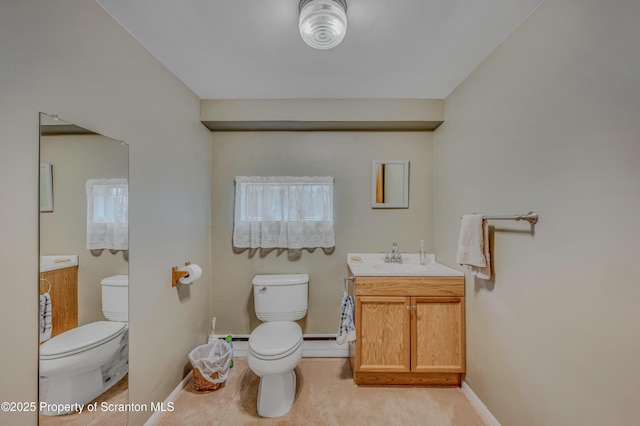 bathroom featuring a baseboard heating unit, vanity, and toilet