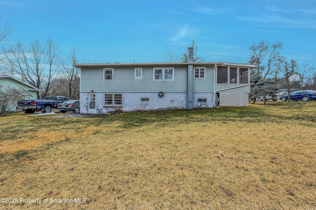 back of property featuring a sunroom and a lawn