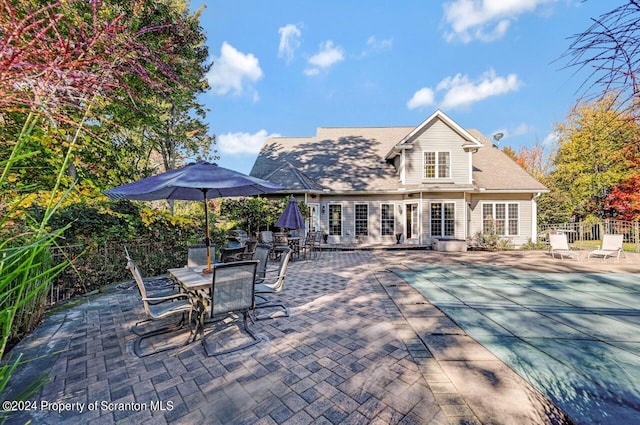 rear view of house with a patio and a covered pool