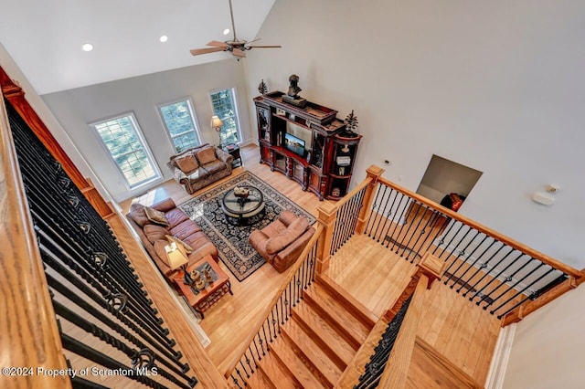 living room with ceiling fan, high vaulted ceiling, and hardwood / wood-style flooring