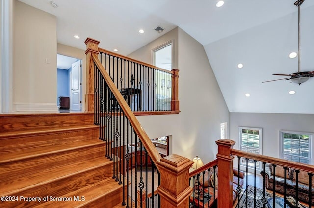 stairway with ceiling fan and lofted ceiling