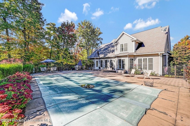 back of property with a patio and a covered pool