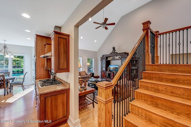 stairway with hardwood / wood-style floors, ceiling fan, and lofted ceiling