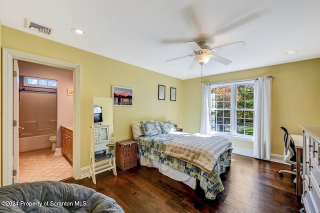 bedroom featuring connected bathroom, dark hardwood / wood-style floors, and ceiling fan