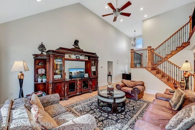 living room featuring light hardwood / wood-style flooring, high vaulted ceiling, and ceiling fan