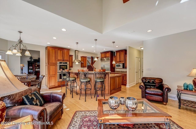 living room with light hardwood / wood-style flooring, a chandelier, and sink