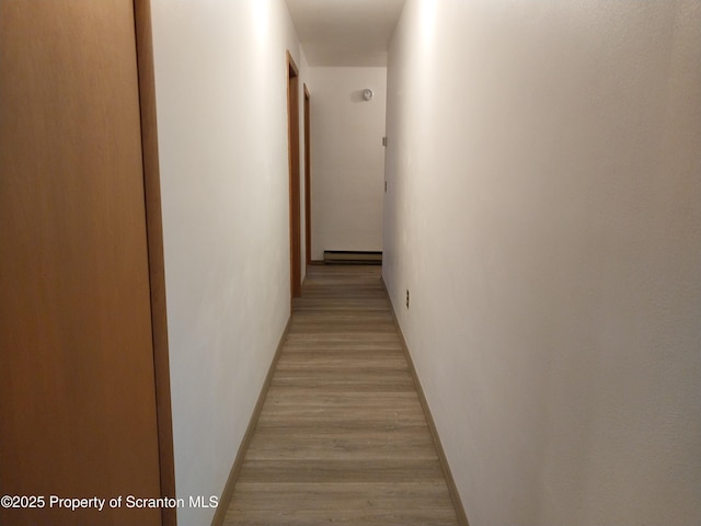 hall featuring a baseboard radiator and light hardwood / wood-style floors