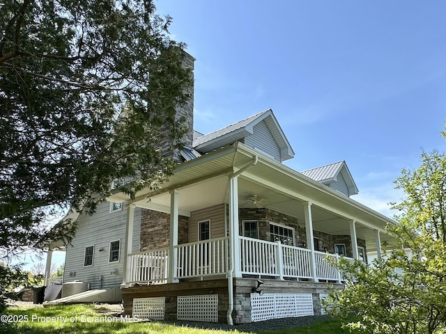 185 Southpoint Rd, Montrose, PA 18801 - view of side of home featuring covered porch, stone siding, a chimney, and metal roof