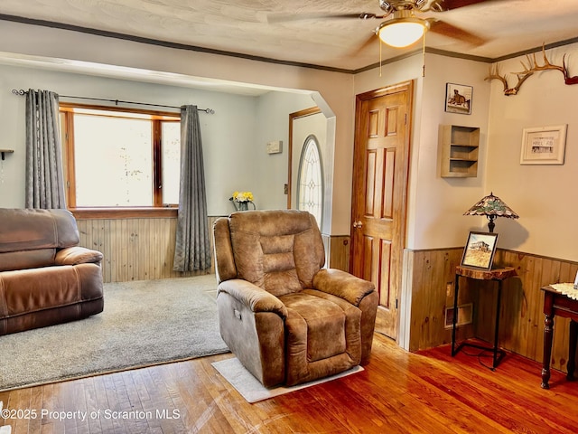 4886 State Route 11, Hop Bottom, PA 18824 - sitting room featuring a wainscoted wall, wood walls, ceiling fan, arched walkways, and wood-type flooring