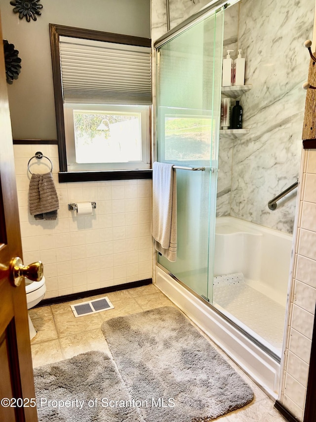 4886 State Route 11, Hop Bottom, PA 18824 - bathroom with a shower stall, toilet, visible vents, and tile walls