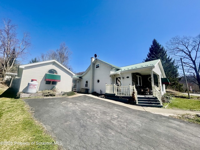 4886 State Route 11, Hop Bottom, PA 18824 - view of front facade featuring metal roof, driveway, a chimney, and covered porch