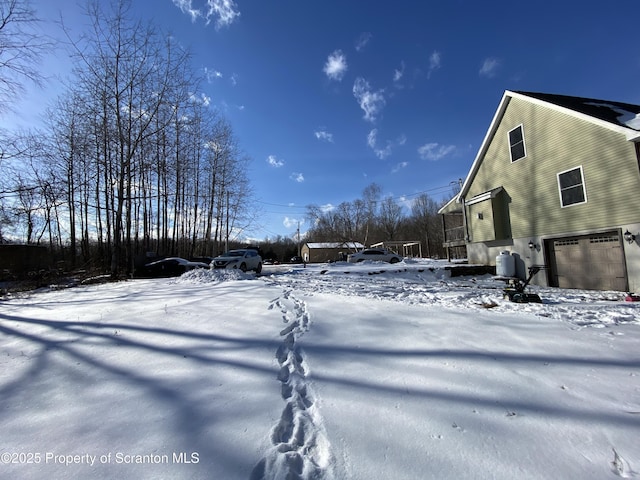 yard layered in snow featuring a garage