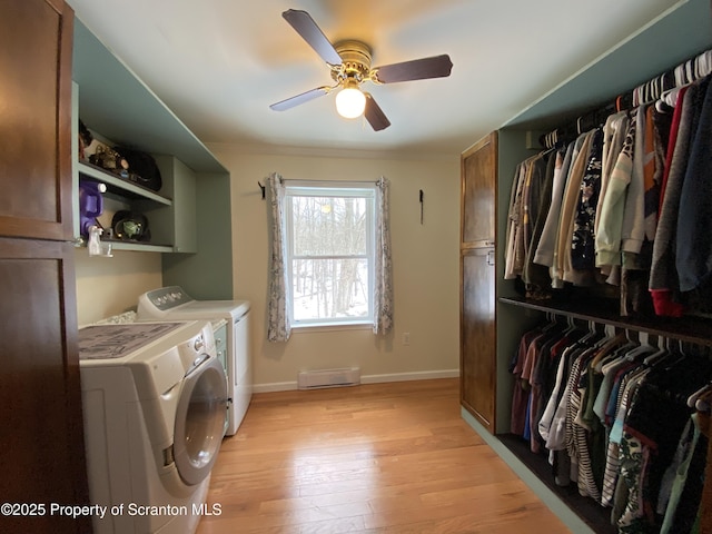 clothes washing area featuring ceiling fan, washer and clothes dryer, and light hardwood / wood-style flooring