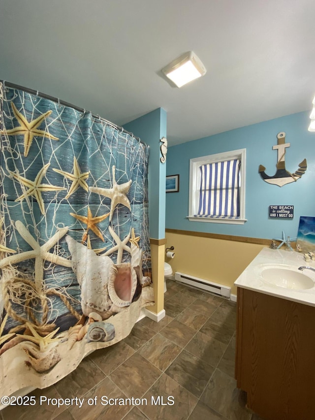 bathroom with vanity, baseboard heating, and toilet