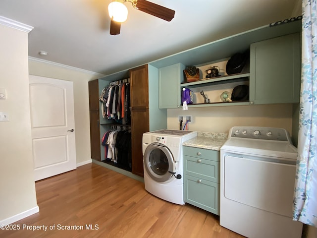 laundry room featuring cabinets, ornamental molding, washer and clothes dryer, ceiling fan, and light wood-type flooring