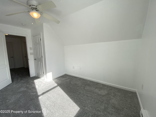 bonus room with vaulted ceiling, dark carpet, and a baseboard heating unit