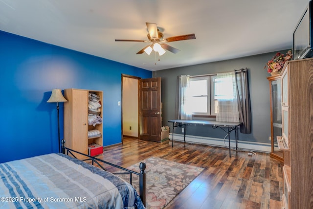 bedroom with baseboards, baseboard heating, a ceiling fan, and wood finished floors