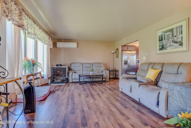 living area featuring a wall mounted AC and wood finished floors