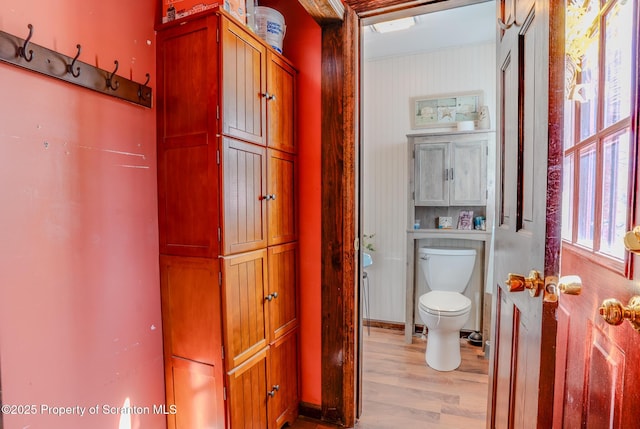 bathroom featuring plenty of natural light, toilet, and wood finished floors